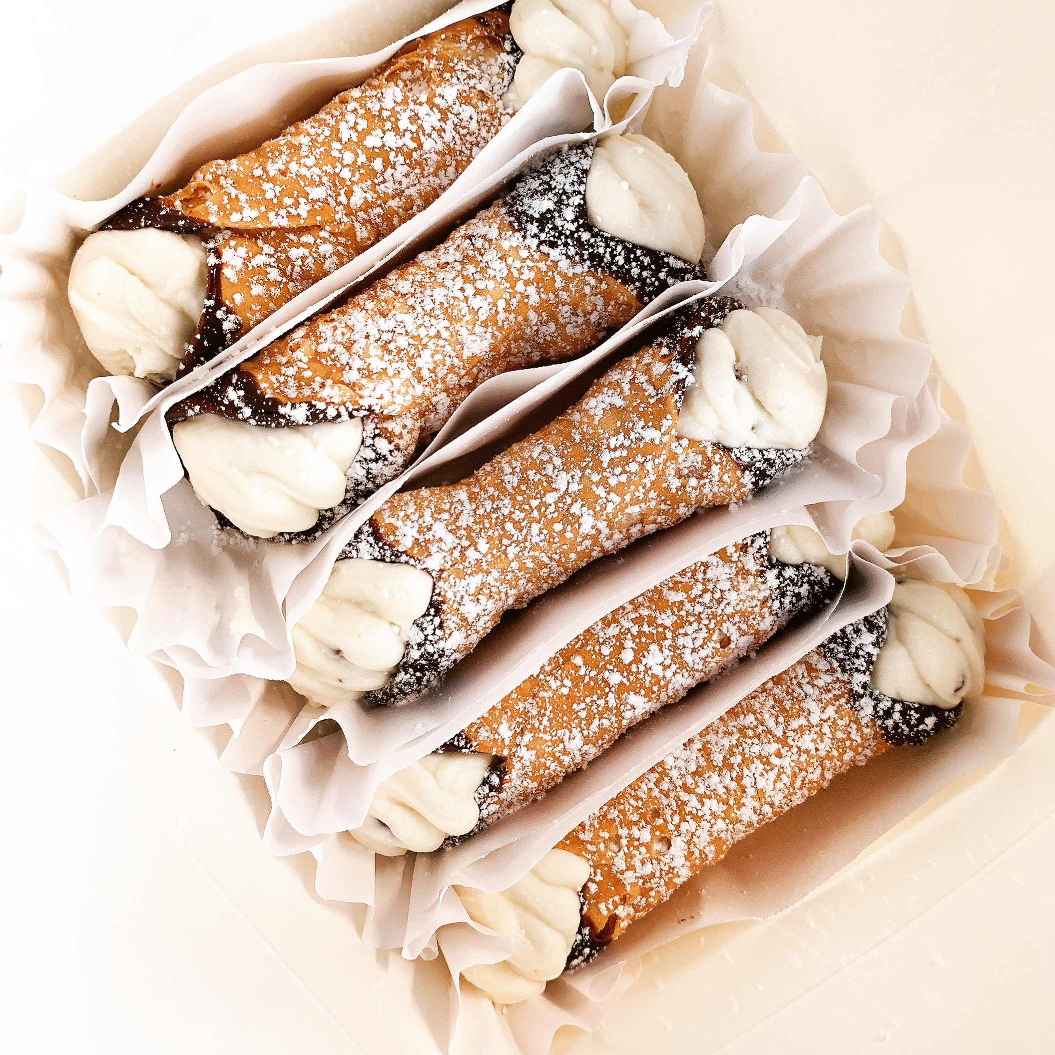 Fresh cannoli dusted with powdered sugar